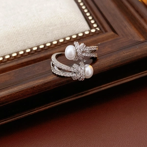 Detail of silver knot ring with two white pearls and shimmering zircon stones