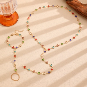 Detail view of gold bohemian jewelry set with multi-colored heart-shaped gemstones