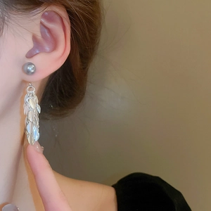 Détail de boucles d'oreilles pampilles feuilles argentées avec perle grise sur modèle