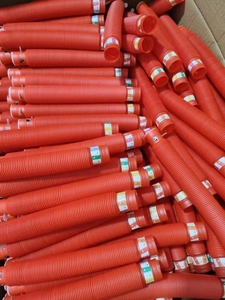 Close-up of bulk red plastic telescopic sensory tubes in a box for stress relief