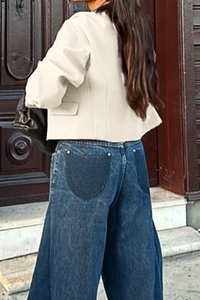 Rear view detail of beige cropped jacket and wide-leg denim jeans with round pocket patchwork