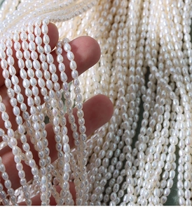 Macro shot of high-luster 4mm white rice-shaped natural freshwater pearls on strings