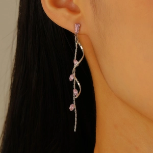 Side view of long silver tassel earrings with pink marquise-cut zircon on model