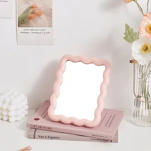 Pink wavy desktop makeup mirror in a stylish INS aesthetic for a refined vanity desk