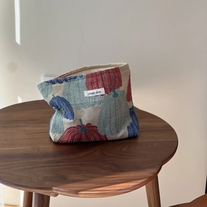Large jacquard makeup bag with colorful pumpkin weave on a wooden table setup