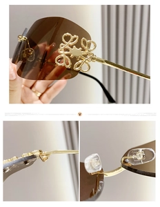 Detail of gold metal temples with luxury anagram logo and brown rimless sunglasses lenses