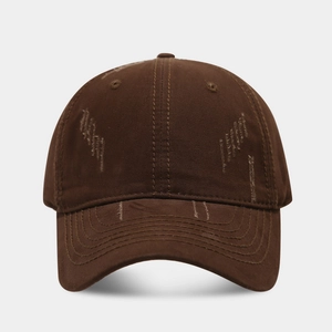 Detailed macro view of distressed cotton twill fabric on dark brown baseball cap