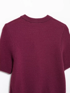 Detailed macro view of the Bordeaux red plush knit fabric texture and ribbed crew neckline
