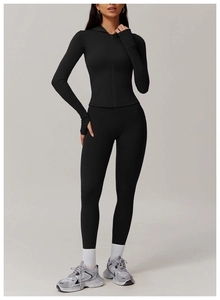 Detail view of black zip-up hooded jacket and high-waist yoga leggings set with thumb holes