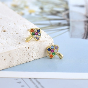 Detail view of gold mushroom stud earrings set with vibrant colorful cubic zirconia