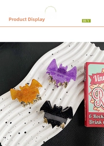 Detail of glitter bat hair claws in purple, orange and black with gold metal clips