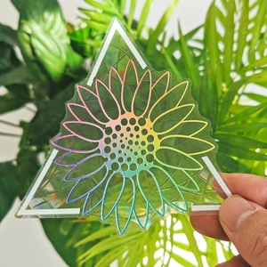 Close-up of a holographic triangle suncatcher sticker with a vibrant sunflower design