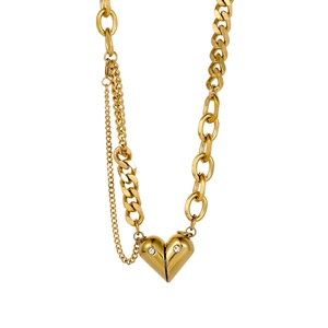 Detail of gold heart pendant necklace featuring clear zircons and asymmetric Cuban chain
