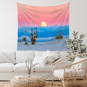 Detail of bohemian landscape tapestry showing a purple sunset over white sofa decor
