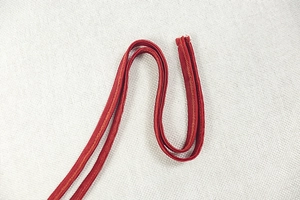 Detailed macro view of red mesh dress straps with double-stitched parallel sewing quality