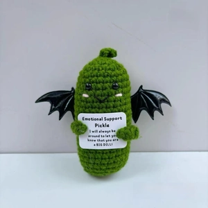 Detail of handmade green crochet emotional support pickle doll with wings and card