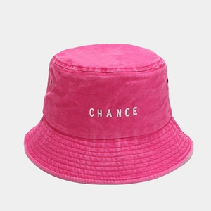 Close-up of CHANCE embroidery on a washed pink canvas bucket hat with metal eyelets