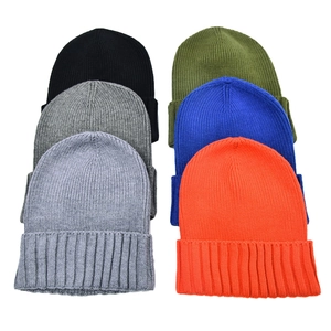 Flat lay of six solid-color rib-knit beanies showing various winter color options