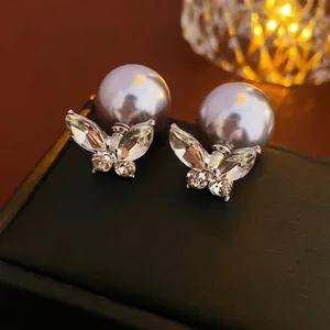 Elegant gold-plated butterfly stud earrings with purple pearls and zircon crystals