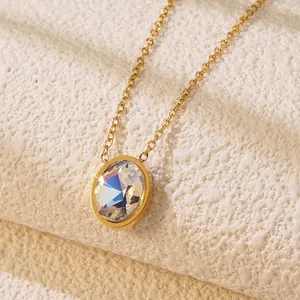 Close-up of elegant gold necklace featuring a faceted oval clear crystal pendant on stone