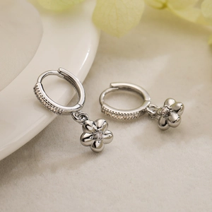 Elegant silver flower drop earrings with sparkling zircon crystals on white porcelain