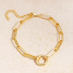 Detailed top view of a gold-plated paperclip chain bracelet with a central circle link