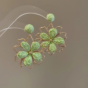 Light green raffia woven flower drop earrings with a metallic frame for summer beach style
