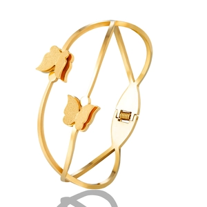 Detail of gold butterfly bangle featuring spring clasp and frosted finish on matte wings