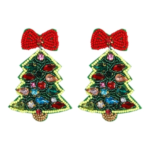 Detailed close-up of handmade beaded Christmas tree earrings with a red bow and colorful gems
