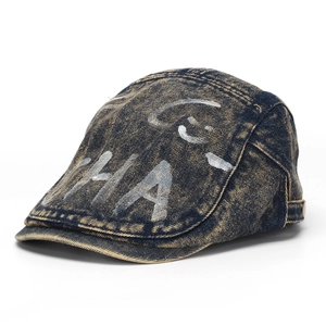 Detail of washed denim newsboy cap with white HA graffiti and metal adjustment buckle