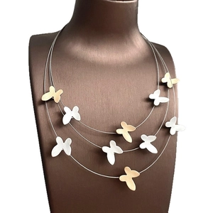 Three-layer butterfly tassel necklace in gold and silver finish with brushed texture