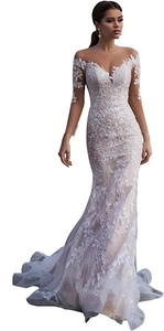 Close-up of white mermaid wedding dress featuring sheer lace sleeves and floral embroidery