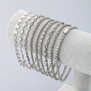 Detail view of eight assorted silver stainless steel anklet chains on a velvet display