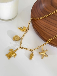 Détail du collier en acier inoxydable doré 18K avec breloques d'étoile de mer et tortue