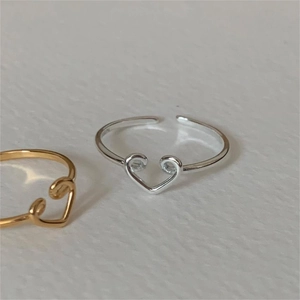 Top view of gold and silver heart-shaped open rings showing adjustable metal band details