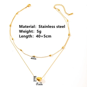 Double-layered stainless steel necklace with small beads and heart pendant on white background