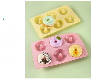 Detailed macro view of 6-cavity silicone donut molds in pink and yellow matte finish
