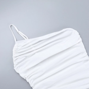 Détail de la robe blanche montrant des plis froncés et une fine bretelle sur le tissu