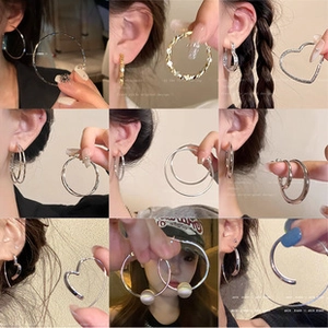 Collage of varied gold and silver hoop earrings and pearl studs worn by a model