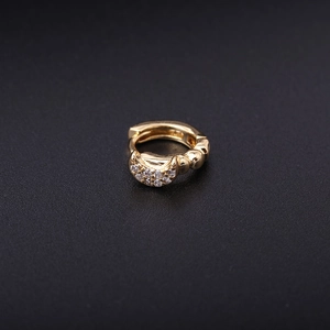 Macro detail of golden star moon hoop earring with sparkling zircon inlay on black surface