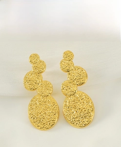 Macro shot of 18K gold plated stainless steel earrings with molten lava texture details