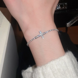 Close-up of elegant silver tennis bracelet with cross motif and sparkling zircons