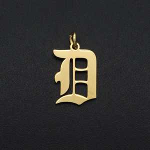 Macro shot of Gothic letter D gold pendant made of polished stainless steel for DIY