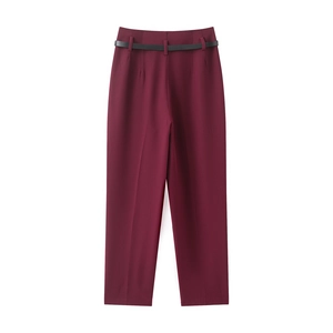 Detail view of burgundy straight-leg trousers with thin black belt and smooth fabric