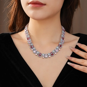 Gros plan d'un collier vintage avec zircons colorés porté par un mannequin chic