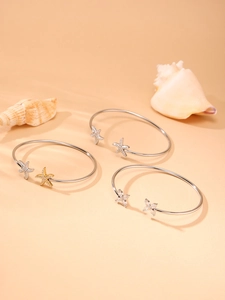 Détail de bracelets ouverts étoile de mer avec zircons brillants et thème nautique