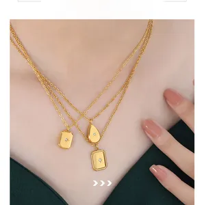Macro detail of triple-layer gold necklaces with geometric star-set pendants