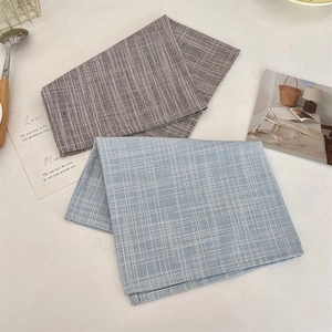 Dettaglio di tovagliette in cotone lino con motivi a scacchi blu e strisce marroni