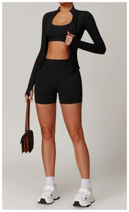 Detail view of black seamless yoga set including zip-up jacket, sports bra and gym shorts