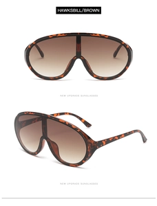 Detail showing oversized hawksbill patterned frames with brown gradient lenses
